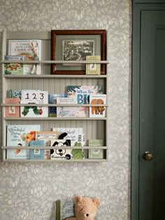 a teddy bear sitting on top of a chair next to a shelf filled with books