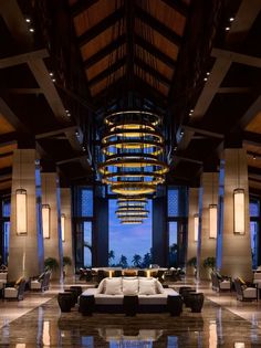 a large lobby with high ceilings and chandeliers hanging from it's ceiling