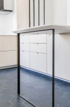 an empty kitchen with white cabinets and blue flooring