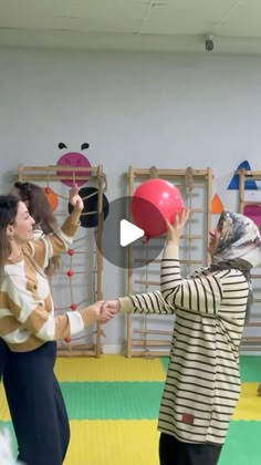 two women are playing with balls in a room