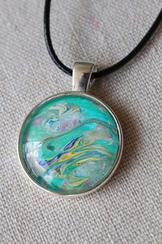 Unique, Colorful, Fun, Bohemian Fluid Art Necklaces. Every necklace is a unique work of art. Made using acrylic fluid art techniques and crafted by selecting the most attractive of color blends and compositions. These necklaces are playful, colorful, and are great additions to any ladies' wardrobe.  They make perfect gifts for any special women in your life whether that be your mother, mother-in-law, your daughters, coworkers, close friends, and they even make a great gift for yourself! Availabl Artistic Green Round Pendant Necklace, Artistic Handmade Green Necklace, Artsy Multicolor Necklaces With Artistic Design, Artistic Green Handmade Necklace, Artsy Hand Painted Green Necklace, Artsy Multicolor Round Pendant Jewelry, Colorful Artsy Necklace For Gifts, Colorful Artsy Necklace For Gift, Artistic Multicolor Round Pendant Jewelry