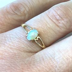 Petite Natural Oval Opal 10k Yellow Gold Ring ~ Size 6 ~ October Birthstone Ring -  ET2430 This opal has beautiful blue coloring with hints of pink. Ring Size: 6- can be resized Metal Content: 10k Yellow Gold Gemstones: Natural Opal Oval Cabochon - .23 ct Measurements: Ring face (North/South): 6mm Height of ring off of finger: 4mm Ring Shank Width: 2mm Weight: 1.27 Grams Stamps: 10k Condition: Excellent Estate Items will ship in a gift box or pouch Each piece is thoroughly examined and refinished as needed by our professional jewelers, tested to guarantee metal content,  graded by our in-house GIA (Gemological Institute of America) Graduate Gemologist, and inspected for quality before being carefully packaged and promptly shipped. Thank you for taking the time to shop with us! We have hund October Birthstone Ring, October Birthstone Rings, Ring Shank, North South, Pink Ring, October Birthstone, Opal Ring, October Birth Stone, Yellow Gold Ring