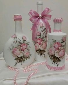 three bottles with pink roses painted on them