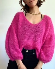 a woman wearing a pink sweater and black pants