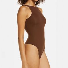 a woman in a brown bodysuit