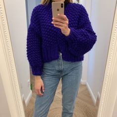 a woman is taking a selfie in the mirror with her cell phone and wearing a purple sweater