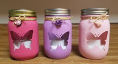 three painted mason jars with butterflies on them