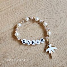 a bracelet with the word dance written on it and an arrow charm attached to it