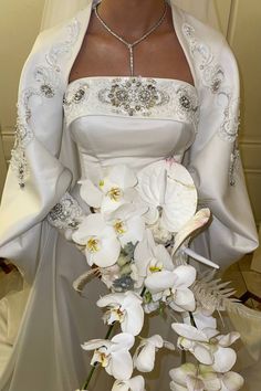 a woman in a wedding dress holding a bouquet of flowers