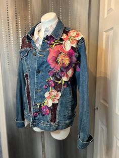 a denim jacket with floral appliques on it