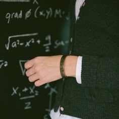 a close up of a person's hand near a blackboard