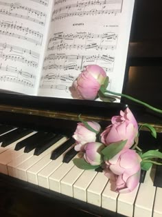 some pink flowers sitting on top of a piano