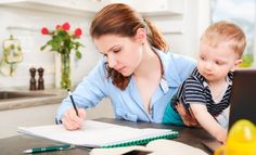 a woman is working on her laptop with a child