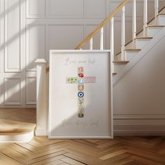 a framed cross on the floor next to a stair case