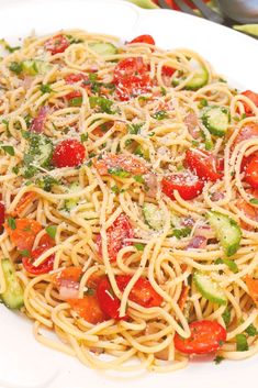 a white plate topped with pasta and veggies