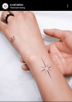 two hands holding each other with small tattoos on their wrist and the same tattoo design