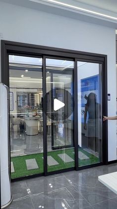 a man standing in front of a glass sliding door