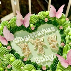 a heart shaped cake decorated with green icing and pink butterflies on it's sides