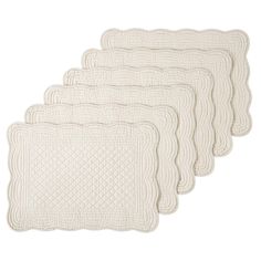 four white quilted placemats on a white background