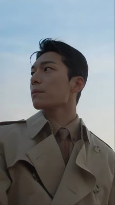 a man in a trench coat looking off into the distance