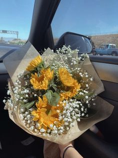 sunflowers and baby's breath in the back seat of a car