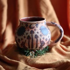 a ceramic mug sitting on top of a blanket