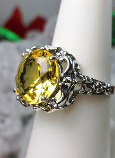 Simulated Yellow Citrine Ring Description Speechless Design#103 MADE TO ORDER Inspired by Victorian era filigree designs, I now offer this stunning Antique inspired ring in sterling silver. This fabulous ring is set with a 6ct flawless Man-made/Simulated citrine gemstone. The round full cut high-quality blue gemstone is 12mm (just shy of 1/2th of an inch) in diameter. The inside of the band is marked 925 for sterling. Notice the beautiful intricate bow and floral-like design of the silver filigr Classic Citrine Crystal Ring, Formal Round Citrine Crystal Ring, Formal Citrine Crystal Round Ring, Formal Citrine Crystal Ring, Topaz Filigree Round Ring, Classic Citrine Jewelry With Diamond Cut, Ornate Round Topaz Gemstone Ring, Victorian Topaz Round Ring, Victorian Topaz Round Jewelry