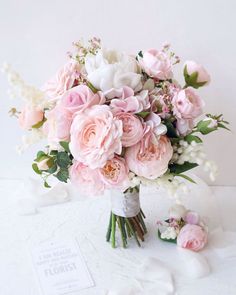 a bouquet of pink and white flowers sitting on top of a table