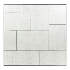 a white tile wall with square and rectangles in the middle, on top of it