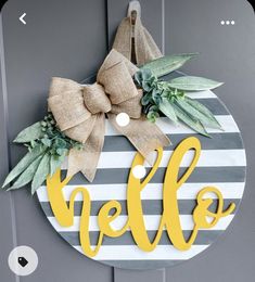 a door hanger with the word hello painted on it and a bow hanging from the front