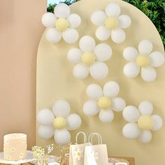 a table topped with cake and white balloons