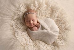 a newborn baby wrapped in a white blanket