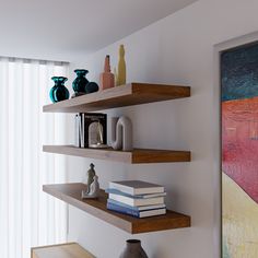 three wooden shelves with books and vases on them in front of a large painting