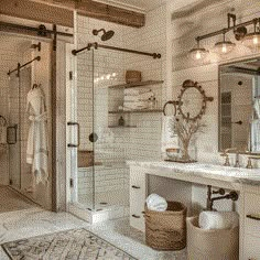 a bathroom with a sink, mirror and shower in it's center area next to a rug on the floor