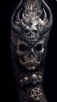 a man's arm covered in tattoos with skulls and demon horns on the side