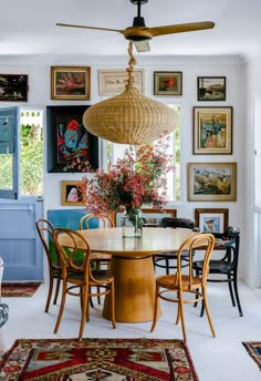 a dining room table with chairs and a fan hanging from the ceiling in front of it