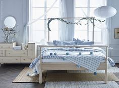 a bed room with a neatly made bed next to a window and a rug on the floor