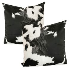 two pillows with black and white cow print on the front, one is made out of fabric