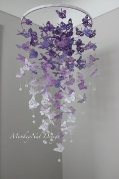 a chandelier with purple butterflies hanging from it's sides in a room