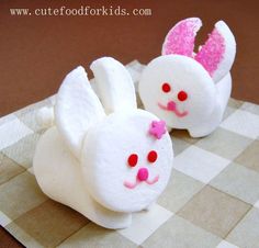 two little white bunnies with pink noses on a checkered table cloth, one is made to look like a bunny