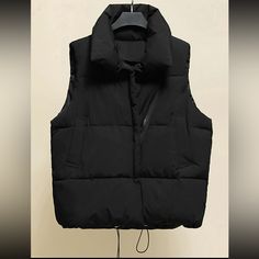 Thick Cozy Puffer Vest With Waist Ties To Tighten, Pockets And Full Front Zipper. Trendy Outdoor Winter Vest, Trendy Winter Vest For Cold Weather, Trendy Black Puffer Vest, Black Puffer Vest For Winter, Black Winter Vest For Cold Weather, Black Vest For Cold Weather And Winter, Casual Black Winter Vest, Trendy Winter Streetwear Vest, Black Winter Vest