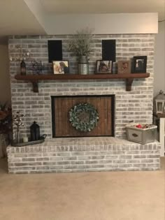 a white brick fireplace with a wreath on the mantel above it and other decorations