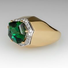 This exquisite cocktail ring is centered with one (1) freeform step cut natural tourmaline set into a six-prong setting and bordered with twenty-two (22), channel set, round brilliant cut diamonds. The ring measures 14.6mm at the top, rises 14.0mm above the finger, tapering to 3.3mm wide and 1.7mm thick at the base of the shank. Signed Schmidt. This ring is currently a size 7. Formal Emerald Ring With Gemstone Accents, Formal Emerald Rings With Gemstone Accents, Modern Green Diamond Ring For Formal Occasions, Fine Jewelry Tsavorite Diamond Ring For Formal Occasions, Formal Tsavorite Rings With Accent Stones, Modern Octagon Emerald Ring For Formal Occasions, Formal Octagon Rings With Gemstone Accents, Green Diamond Ring With Gemstone Accents For Formal Occasions, Classic Formal Emerald Ring With Gemstone Accents