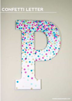 the letter p is decorated with multicolored polka dot paper and stands in front of a white wall