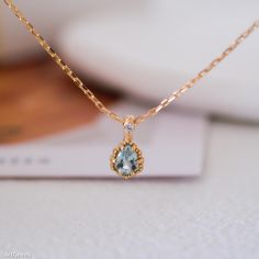 Embrace the serene beauty of our Teardrop Aquamarine Necklace, featuring a tiny aquamarine pendant. This elegant blue stone necklace showcases a teardrop-shaped aquamarine, a gemstone known for its calming energy and clarity. As the birthstone for March, aquamarine is a perfect gift for those born in this month. This necklace is a versatile accessory, ideal for both everyday wear and special occasions. Whether you're celebrating a March baby or looking for a thoughtful gift for her, this necklac Light Blue Birthstone Pendant Jewelry, Light Blue Birthstone Necklace As Gift, Elegant Light Blue Round Pendant Necklace, Dainty Blue Aquamarine Jewelry, Teardrop Aquamarine Necklace For Gift, Aquamarine Gemstone Necklace For Gifts, Blue Teardrop Pendant Necklace Fine Jewelry, Blue Teardrop Pendant Fine Necklace, Blue Topaz Briolette Necklace For Gifts