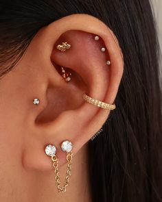 a woman wearing three different types of ear piercings on her left side, and one with