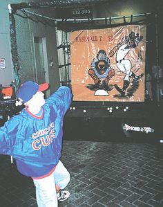 a young boy is practicing his moves in front of an advertisement for the baseball team