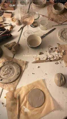 the table is covered with pottery and other crafting supplies, such as paper plates