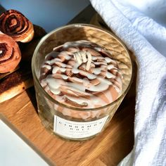 a glass bowl filled with some kind of dessert on top of a wooden cutting board