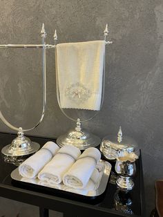 a black table topped with white towels and silver dishes